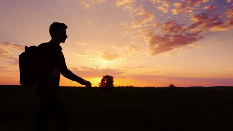 A-Young-Male-Tourist-With-A-Backpack-Looks-At-The-Horizon-Where-The-Sun-Sets