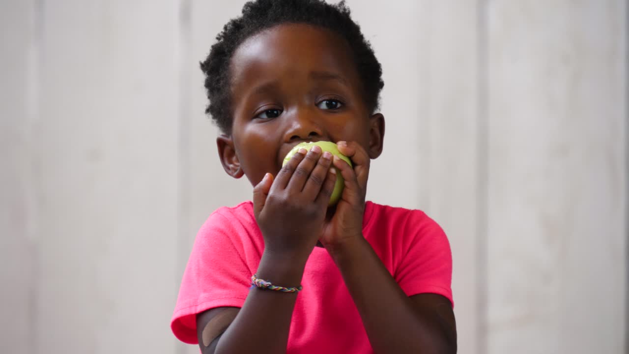Cute African girl eating an apple