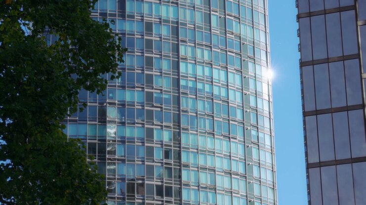Sole che splende dietro un moderno edificio in vetro