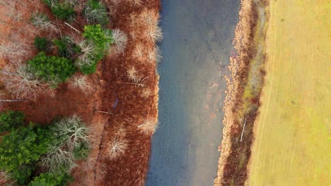 Imágenes-De-Aviones-No-Tripulados-Desde-Arriba-Hacia-Abajo-De-Bosques,-Un-Estrecho-Río-De-Pesca-Y-Un-Campo-Agrícola