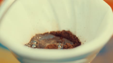 female-hand-pouring-hot-water-on-ground-coffee-in-dripper-Making-Hand-Drip-Coffee-with-paper-filter