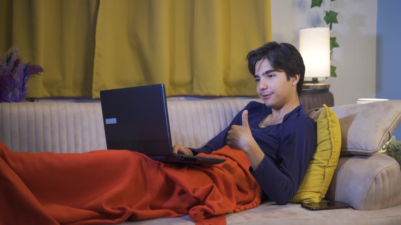 행복한 남자가 노트북을 쓰고 누워 있습니다.