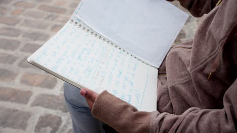 camera shows creative scribbles as kid studies book from behind viewpoint