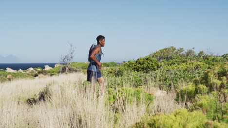 Hombre-Afroamericano-Corriendo-A-Campo-Traviesa-En-El-Campo-En-Una-Montaña