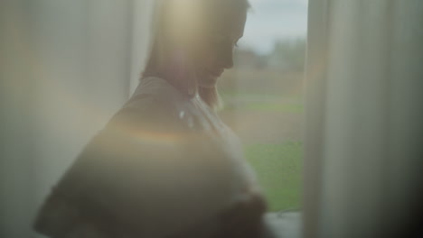 pensive woman by sunlit window