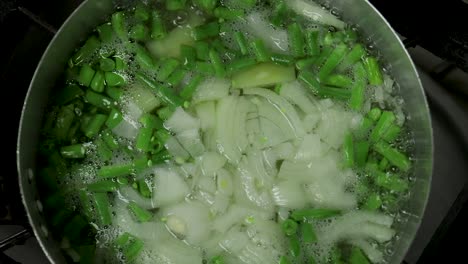 Nahaufnahme-Von-Grünen-Bohnen,-Kartoffeln-Und-Zwiebeln,-Die-In-Wasser-Kochen