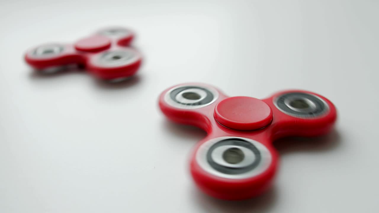 Close up of popular toy fidget spinner rotating over white background
