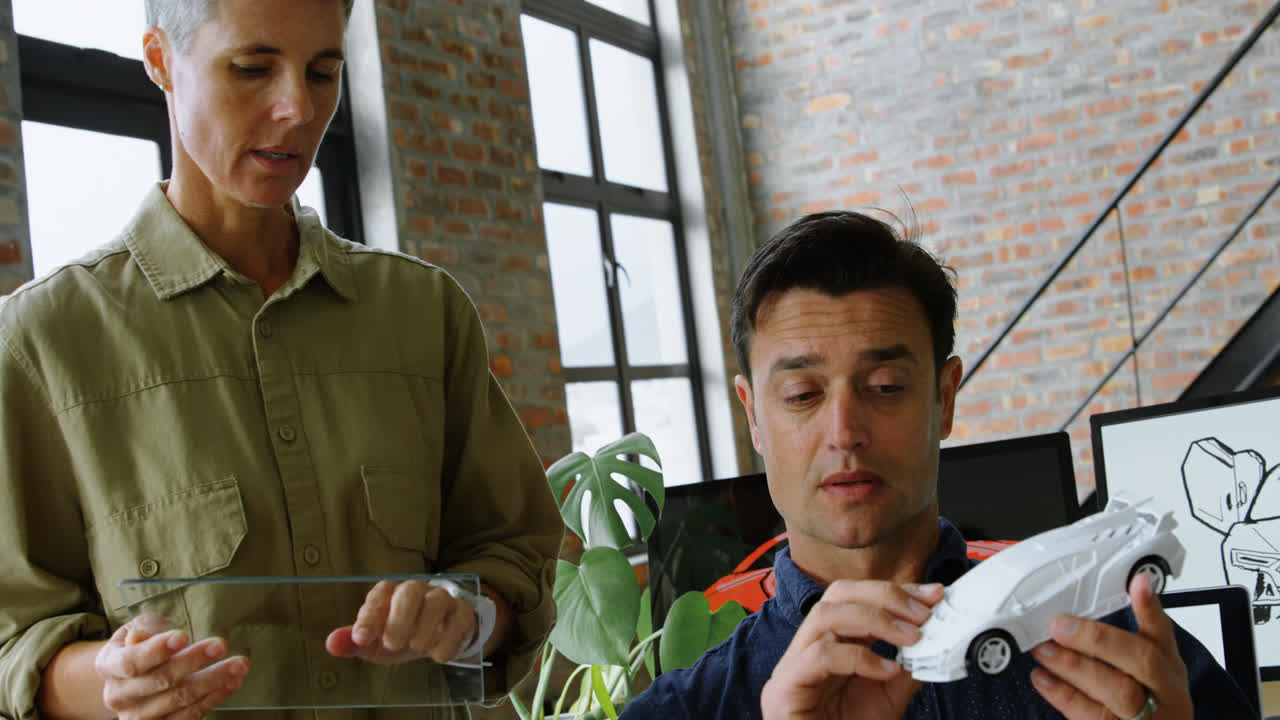 diseñadores de automóviles discutiendo sobre modelos de automóviles en el escritorio 4k