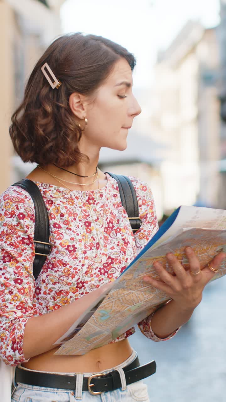 Kvinne går seg vill mens hun reiser i en europeisk by, utforsker, ser på severdigheter og navigerer med et turistkart i papir
