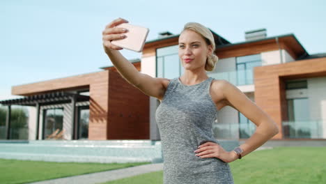 Hermosa-Mujer-Tomando-Una-Foto-Selfie-Fuera-De-Un-Edificio-De-Apartamentos-De-Lujo