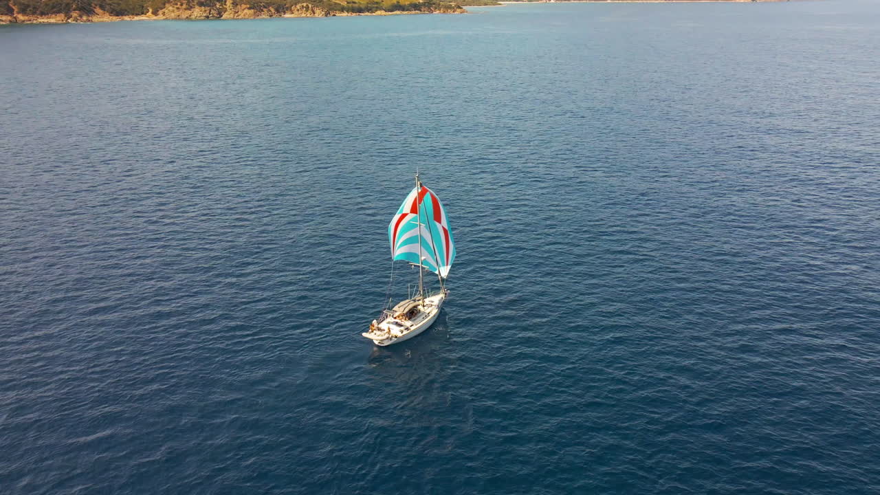 vista aérea del velero con velas de colores en aguas azules del mar mediterráneo