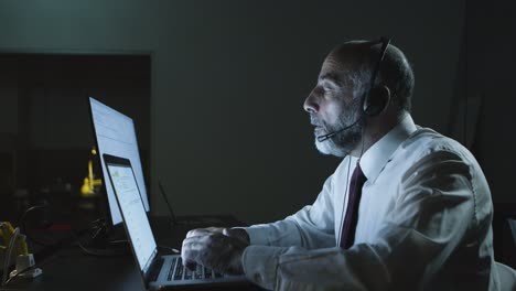 Focused-man-in-headset-using-laptop