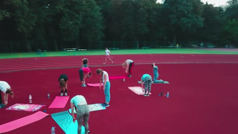 athletic group training on stadium. aerial view of sporty young woman doing workout