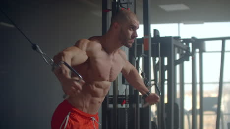 brutal handsome caucasian bodybuilder working out training in the gym gaining weight pumping up muscles and poses fitness and bodybuilding concept.