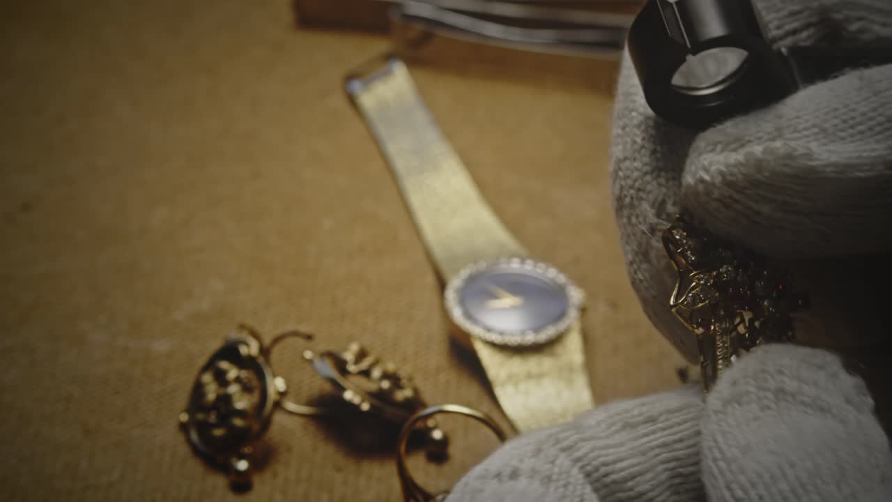 Expert evaluates antique jewellery heirlooms with loupe CLOSE-UP