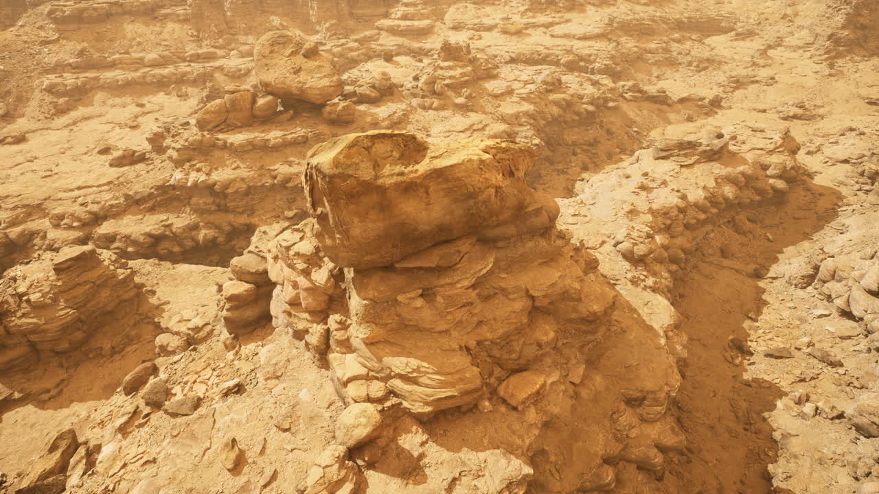 Desert landscape with rock formations highlighted by sunlight and dust