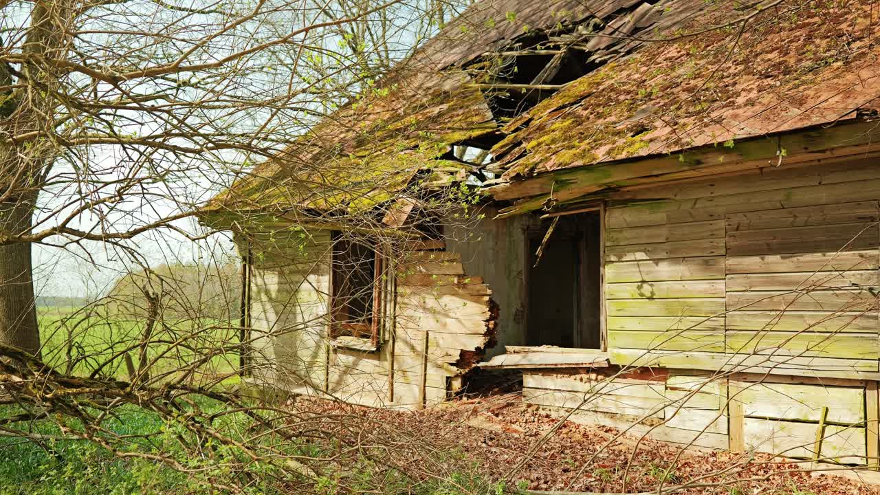 Crumbling walls and moss-covered roof reveal decades of neglect in rural Latvia