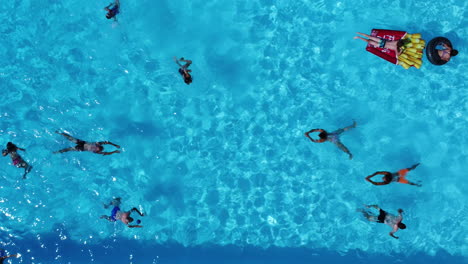 Grupo-De-Turistas-Relajándose-En-Una-Piscina-Durante-El-Verano,-Vista-De-Drones