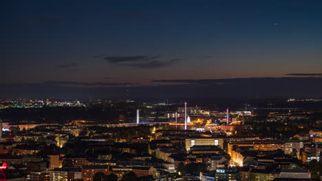 Linnanmaki-amusement-park,-Olympic-stadium-and-the-Kallio-cityscape,-night-in-Helsinki---Time-lapse-shot