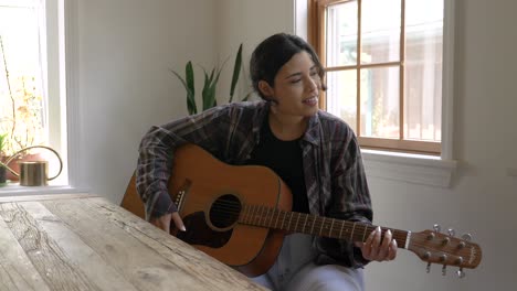 happy puerto rican musician girl playing acoustic guitar and dancing to the beat