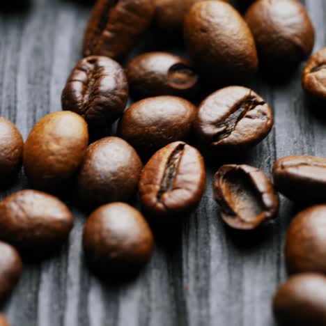 coffee grain. brown roasted coffee beans scattered on wooden surface. natural seeds of coffee. macro shot.