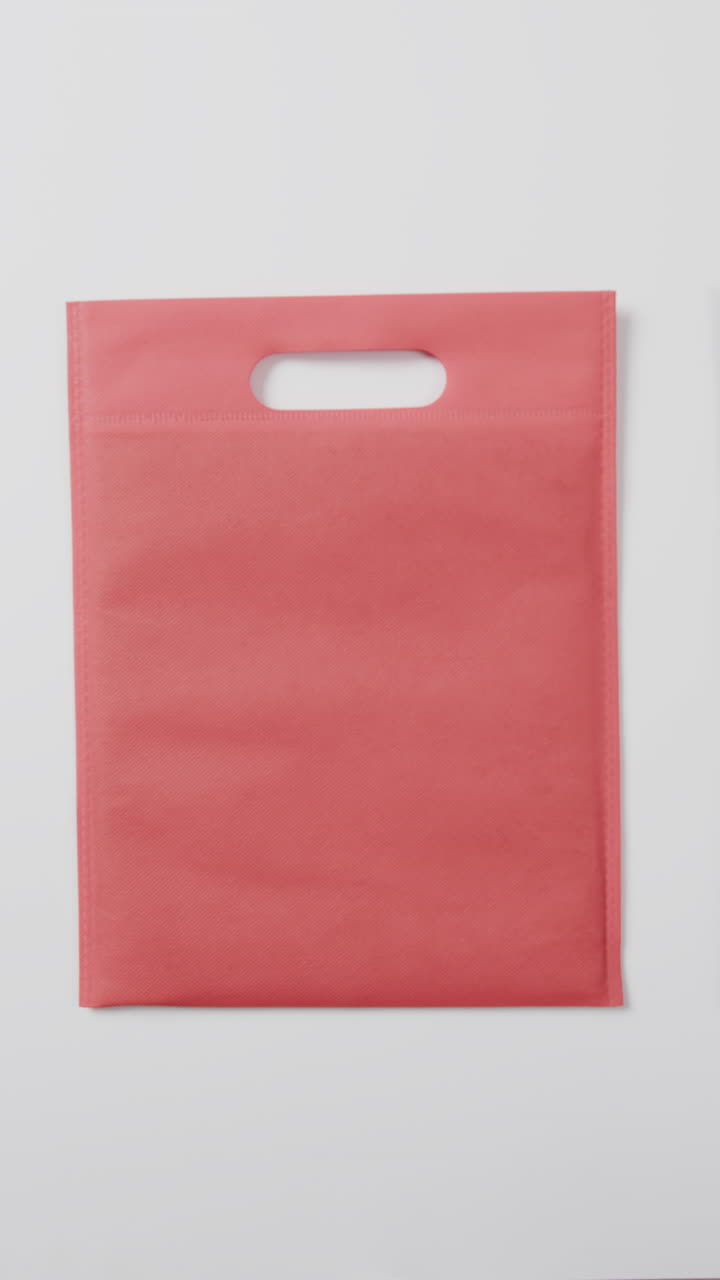 Vertical video of red and black bag and copy space on white background