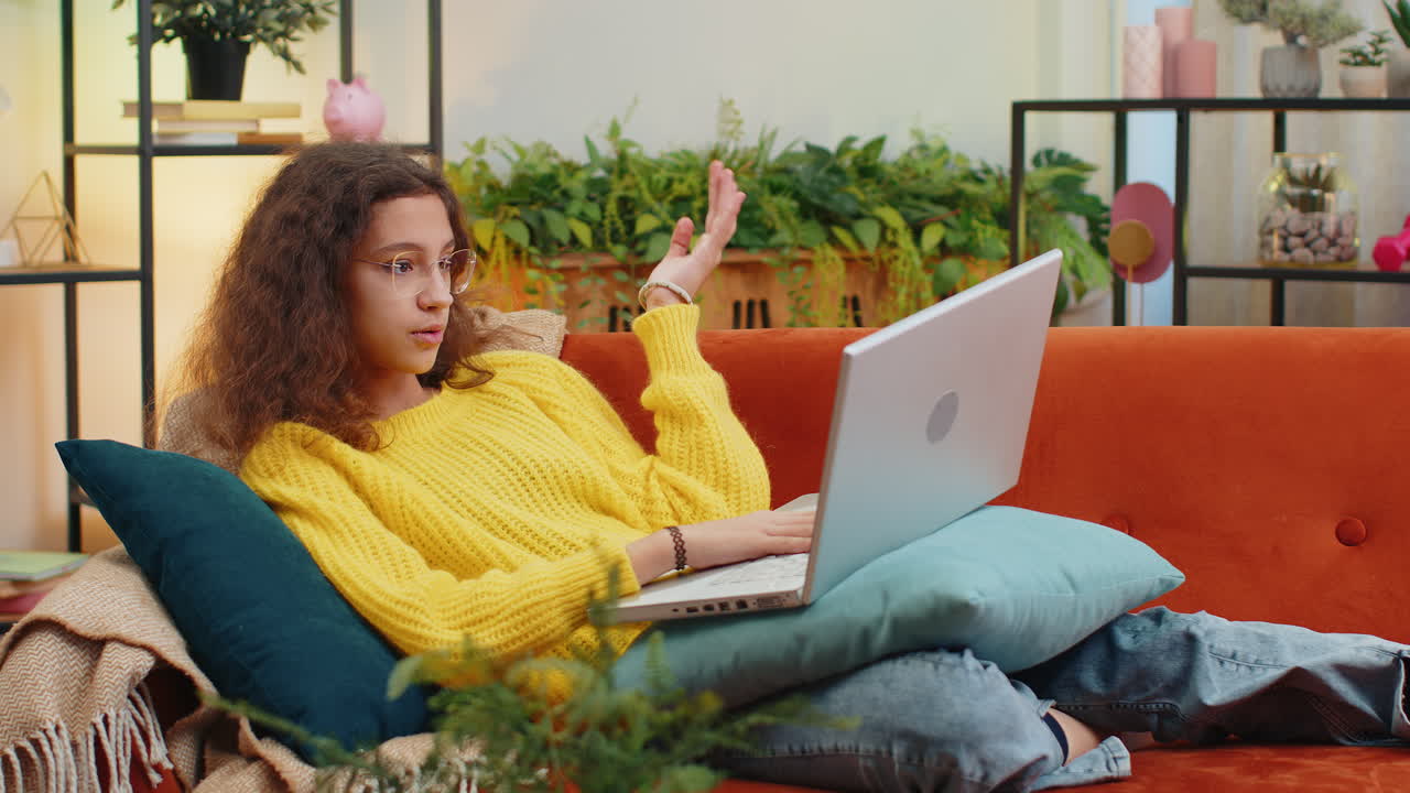 Teen child girl looking at laptop camera making video webcam conference call with friends family