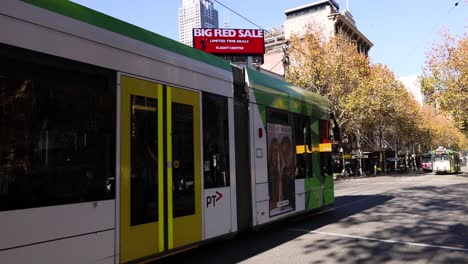 a tram moves through a busy melbourne street