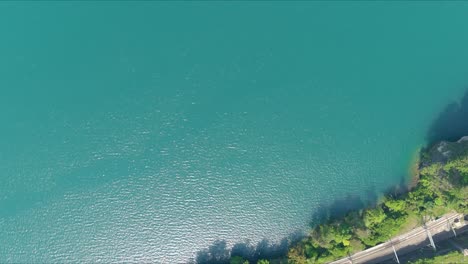 morschach flyover: moving over scenic water valley towards alps mountains, switzerland, europe, drone | movement over road cliffside to majestic blue lake