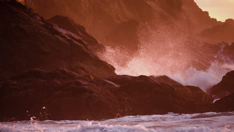 stormy waves hitting rugged shore mountains during sunset