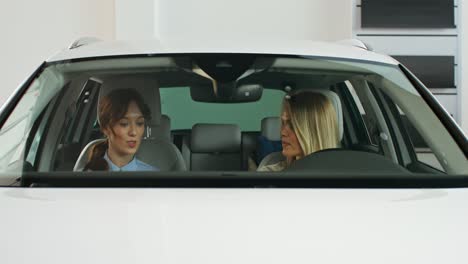 two women in a car at a dealership