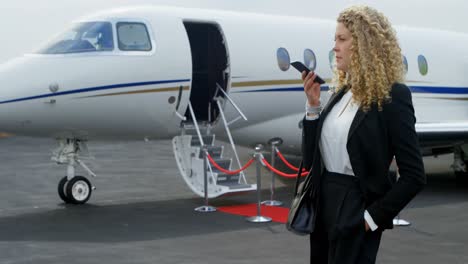 mujer de negocios hablando por teléfono móvil en la terminal 4k