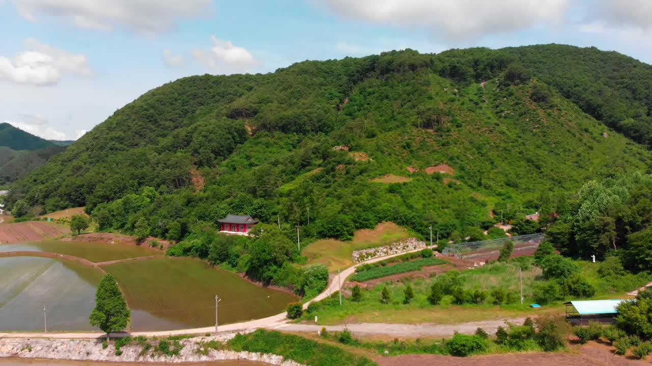 Low altitude aerial fly in towards asian temple