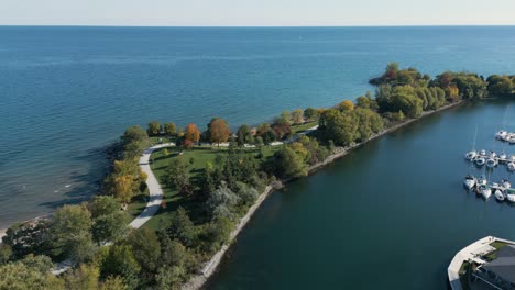 drone shot of a park that looks like a small island against the lake with boats on a clear sunny day