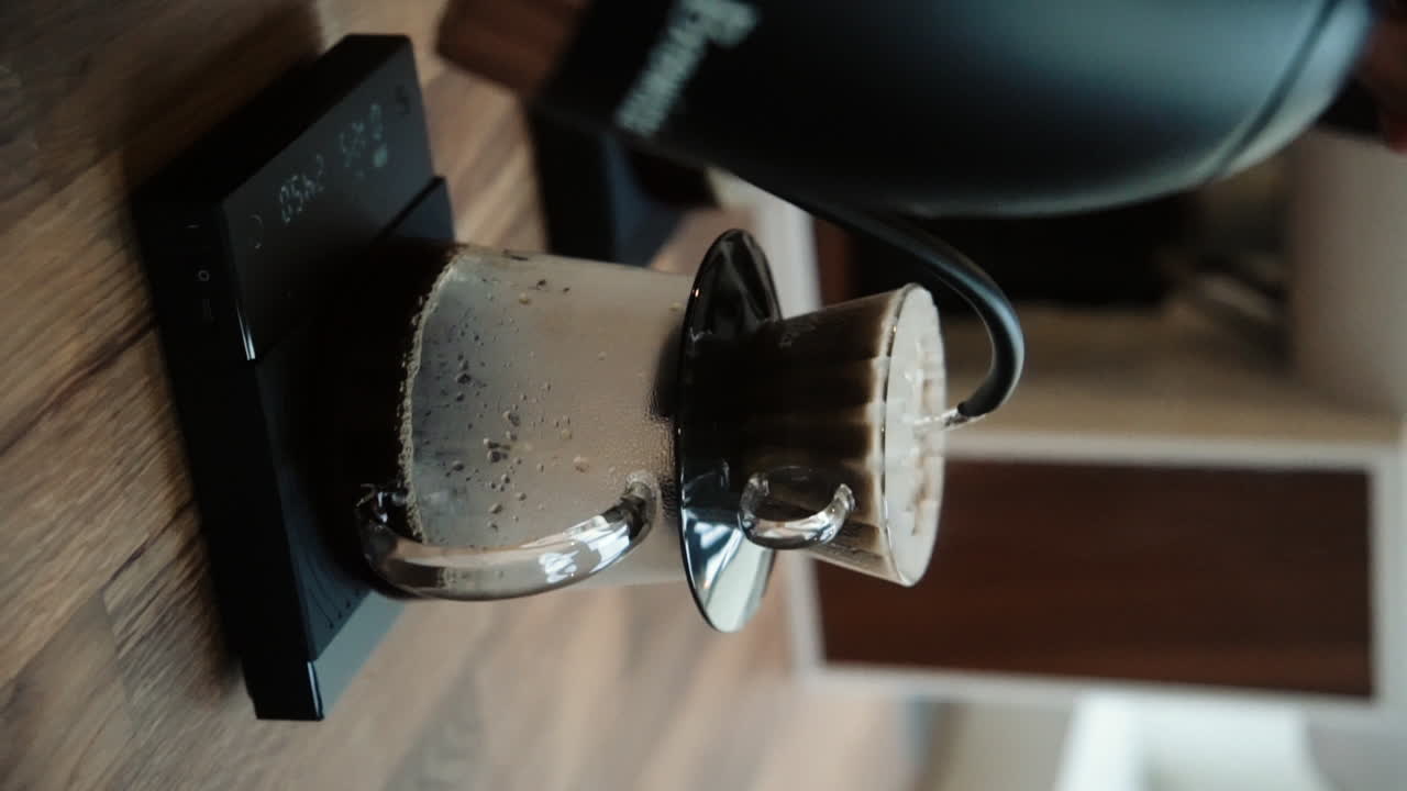 Barista making hand poured black dripped coffee in a coffee shop. Slow Motion Vertical