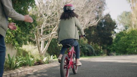 young girl learning to ride a bicycle