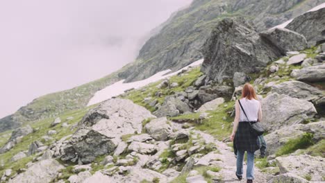 una joven excursionista sube montañas con una cámara fotográfica. transfagarasan, montañas de los cárpatos en rumania