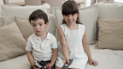 two adorable kids watching movie or show on tv