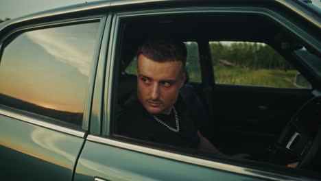 man in vintage car at sunset