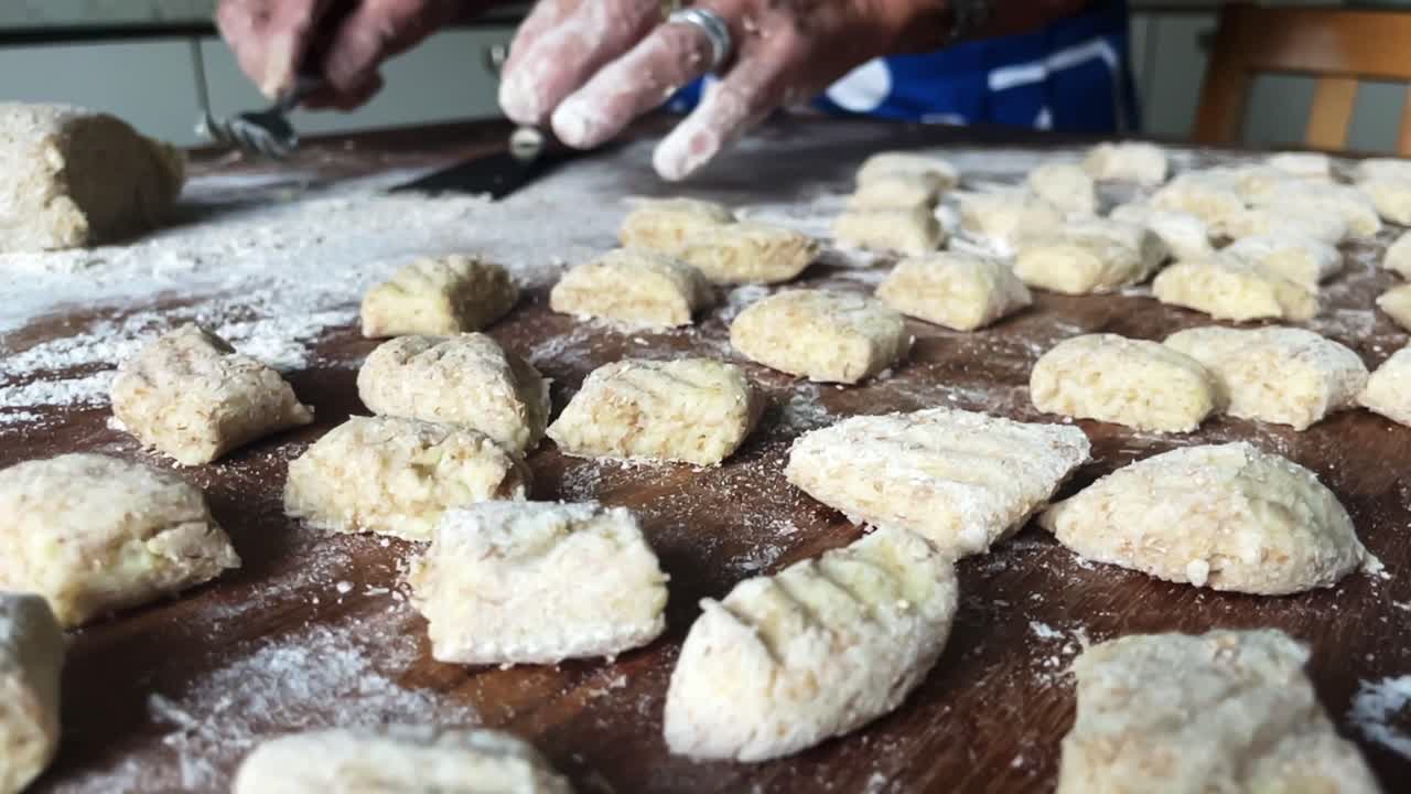 primer plano en cámara lenta manos italianas cocinar gnocchi albóndigas cocina plato tradicional pasta, masa de harina de trigo, patata, huevo y sal