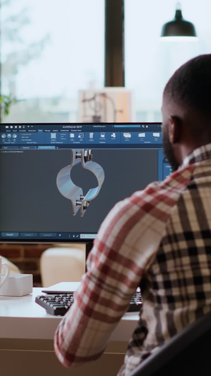 Vertical Video Engineer designs a turbine in an industrial office using CAD software