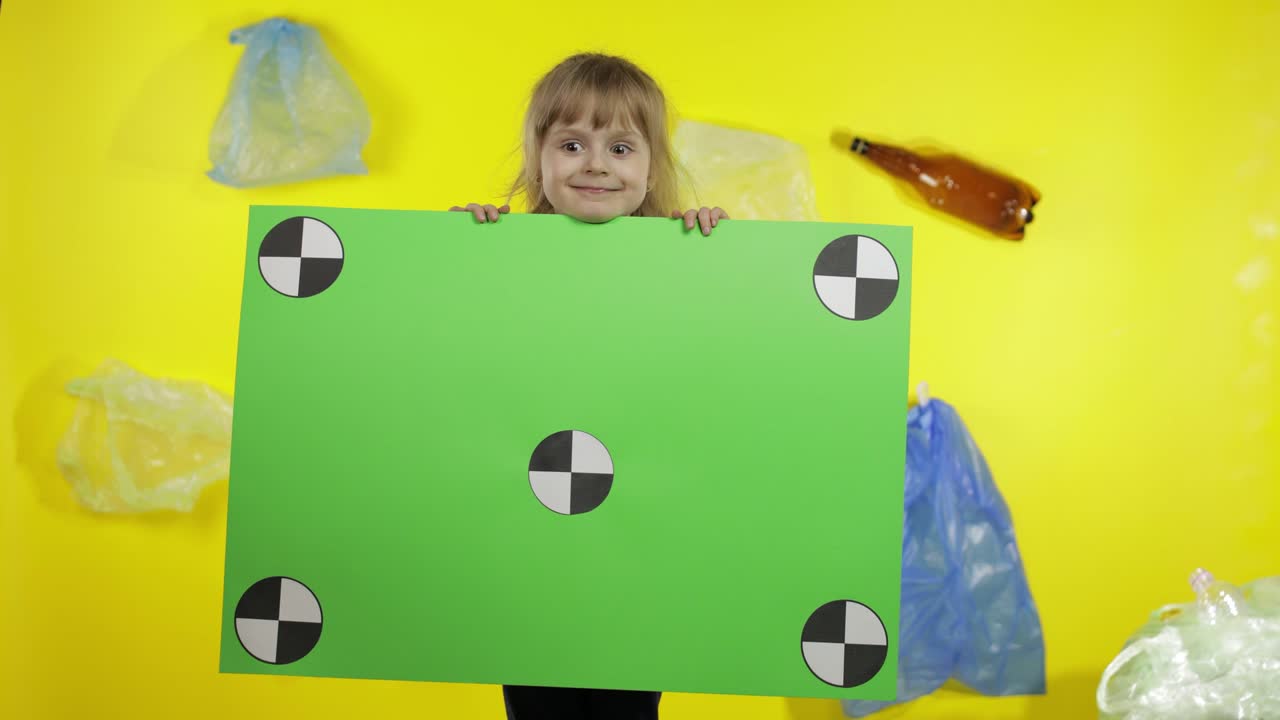 Ragazza attivista che tiene un poster chroma key con punti di tracciamento. Inquinamento ambientale da plastica e rifiuti