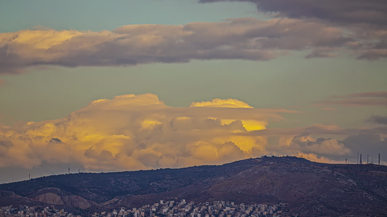 nubes de tono naranja que fluyen sobre las montañas y la ciudad de atenas, lapso de tiempo
