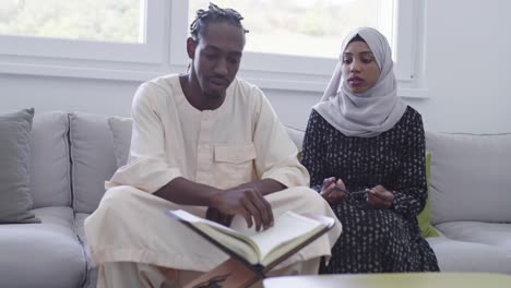 african muslim couple at home in ramadan reading quran holly islam book