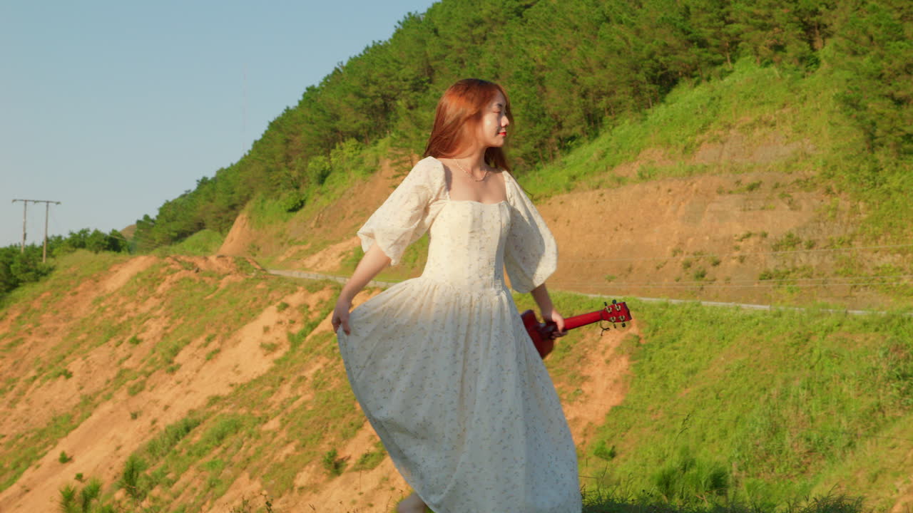 Woman in white dress playing ukulele in the mountains