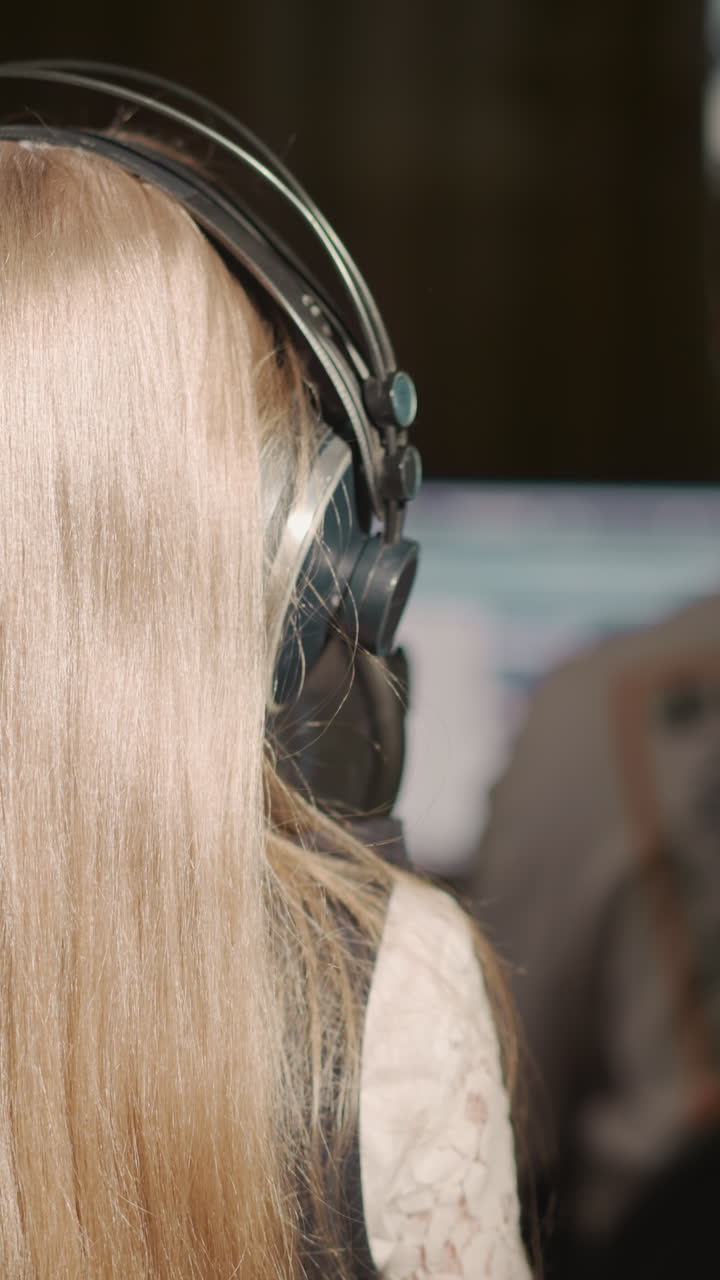 niña canta en el micrófono con el maestro. niña rubia se para frente al tutor mientras practica la voz en el estudio de grabación. niña talentosa