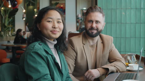 Portrait-of-Positive-Multiethnic-Man-and-Woman-on-Business-Lunch-in-Cafe