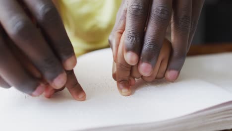 Video-of-african-american-father-and-daughter-reading-braille-alphabet