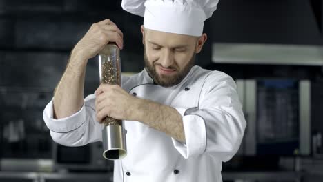 chef hombre cocinando en un restaurante de cocina. chef masculino salpicando la comida en la cocina.