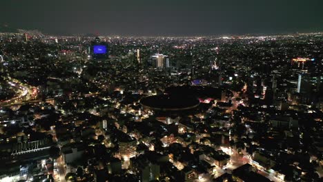 flying over mexico city lit up at night with wtc downtown cityscape skyline, aerial